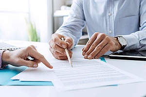 a business owner signing a surety bond agreement with an insurance agent