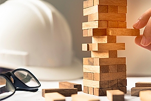 Construction hat and glasses next to wooden Jenga set