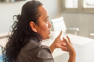 Employee sitting at a conference table talking to the people at the table