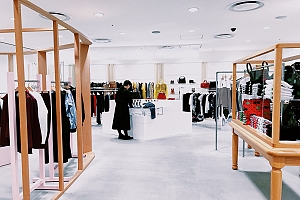 Person in retail clothing store looking at an article of clothing