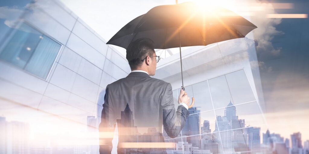businessmen are spreading umbrella during sunrise overlay with cityscape image