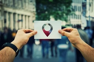 man holding location sign