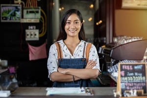 young barista managing her coffee shop that is protected by flood insurance
