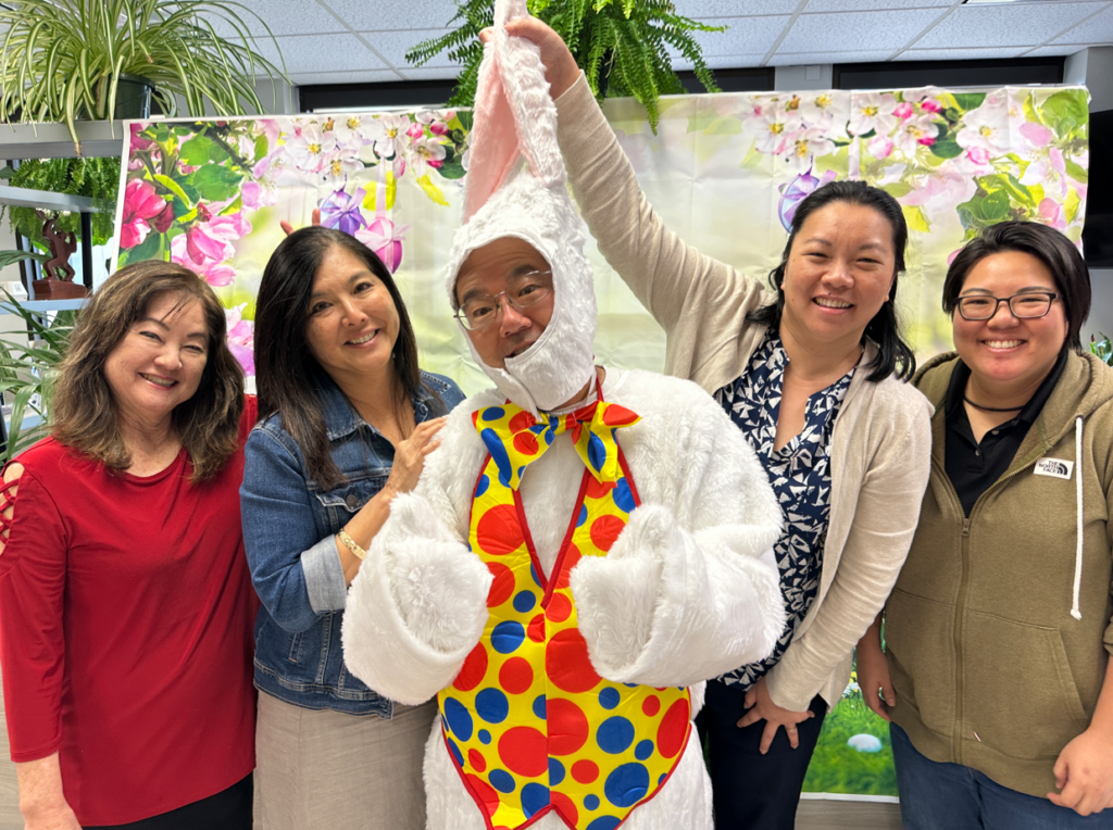This is a picture of Atlas employees taking a photo with an Easter bunny to celebrate the Easter holiday