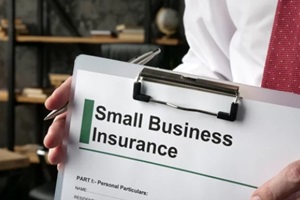 hand holds clipboard with application small business insurance