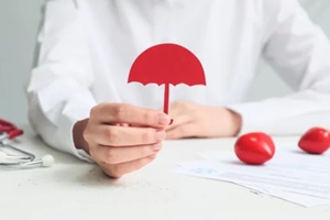 woman with umbrella figure and health insurance form at table
