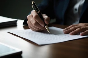 human hands working with documents at desk and signing contract
