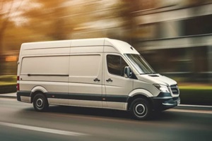 white commercial delivery van on the road in motion blur
