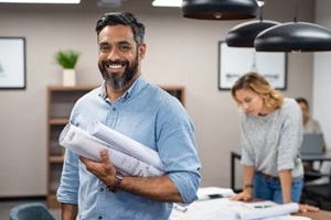 happy latin architect holding blueprints