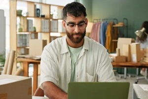 man and laptop in small business for order, inventory check and stock at sme