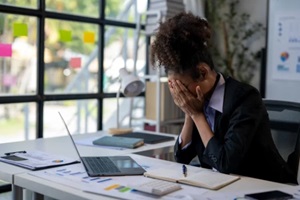 woman in a business suit is crying at her desk