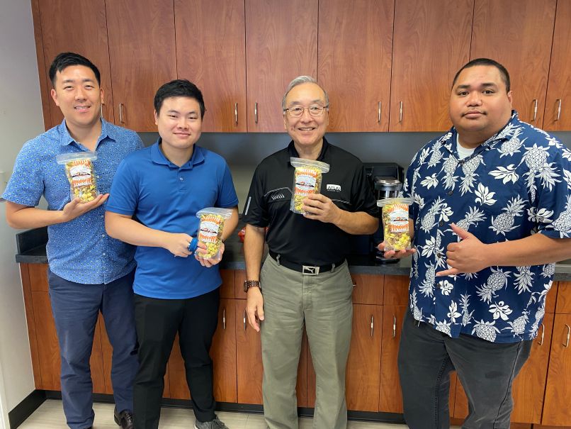 this is a picture of Atlas Insurance Agency employees enjoying the Tsunami Mix popcorn from Island Popper Gourmet Popcorn Shop