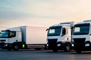 fleet of delivery trucks parked in a row during sunset