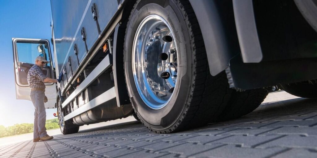 trucker Inspecting semi-trailer tire