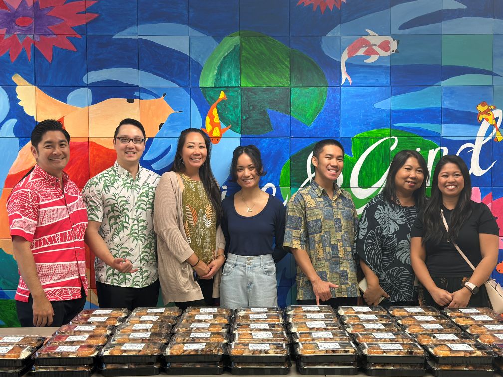 this is a picture of Island Insurance employees providing Atlas Insurance Agency employees with Holiday Bentos