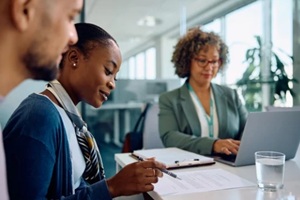 black woman and her husband going through terms of agreement during meeting with insurance agent