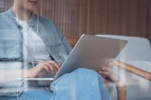 women using laptop and listening to music