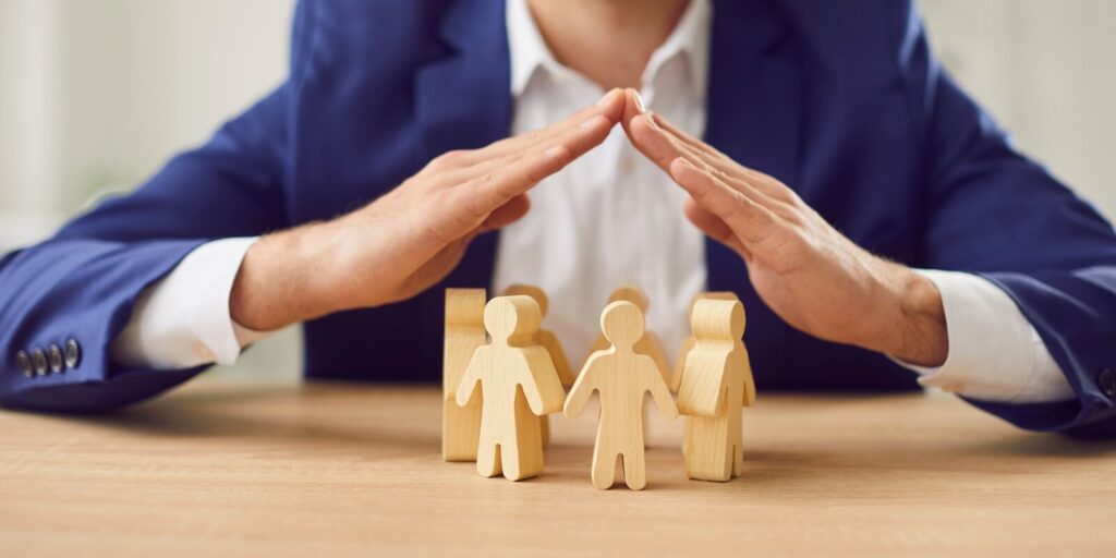 non-profit owner covering wooden figures of people to represent insurance