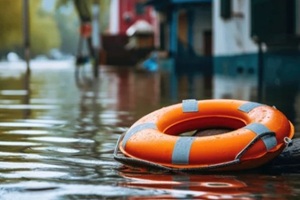 orange lifebuoy floats on the floodwaters in a residential area