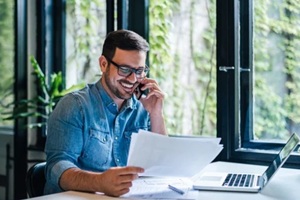 portrait of smiling young male manager working remotely