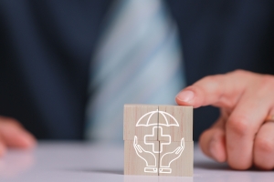 Businessman Hand Arranging Wooden Block with Health Insurance Icon