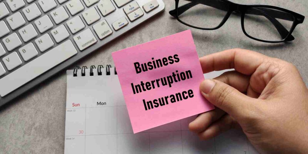 Hand Holding Sticky Note with Text Business Interruption Insurance