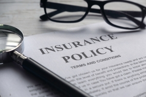 Insurance Policy Documents with Magnifying Glass and Eyeglasses