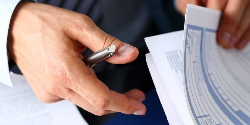 Agent with Business Insurance form Clipped to Pad and Pen