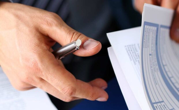 Agent with Business Insurance form Clipped to Pad and Pen