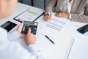 Businessmen Calculating Expenses That Impact Nonprofit Insurance Cost