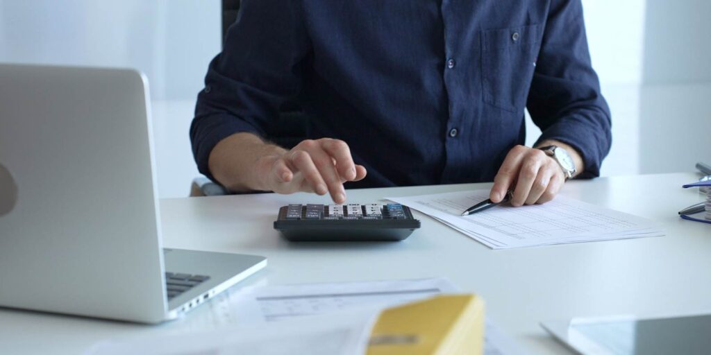 Businessman Calculating Cost of Insurance Set Up for Non-Profit