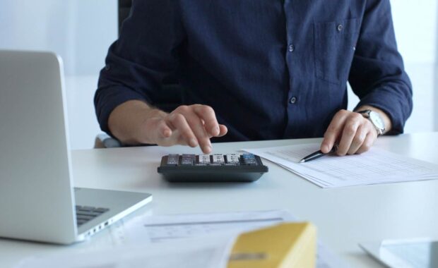 Businessman Calculating Cost of Insurance Set Up for Non-Profit