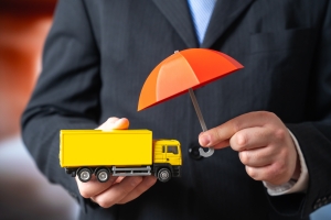 Businessman Holding Umbrella Over Truck Representing Commercial Auto Insurance