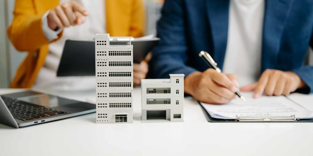 Real Estate Agent Signing Insurance Documents Near Home Models