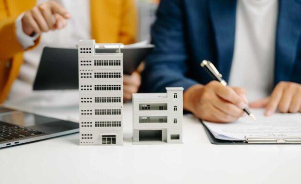 Real Estate Agent Signing Insurance Documents Near Home Models