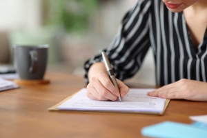 Female Business Professional Reviewing Insurance Renewal Documents on Her Desk