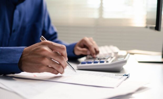 Honolulu Business Owner Calculating Insurance Premium in Office